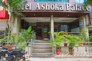 The entrance to Hotel Ashoka Palace with a staircase leading up to the entrance, surrounded by potted plants. - Fabhotel Ashoka Palace (Bhopal)