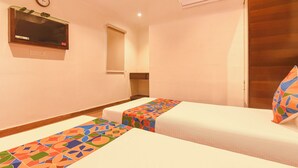 A hotel room with two beds, a TV, an air conditioning unit, and a clock on the wall. - Fabhotel Prime Asl (Kolkata)