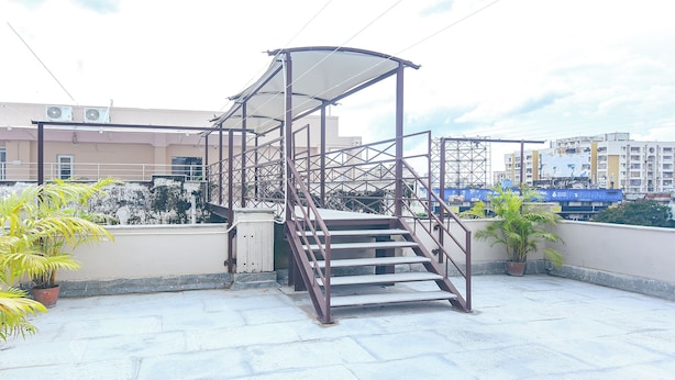 A metal staircase with a canopy on a rooftop terrace. - Fabhotel Prime Asl (Kolkata)