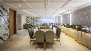 A conference room with a marble wall, a buffet area, and a large window. - Fabhotel Prime Da Marion (New Delhi)