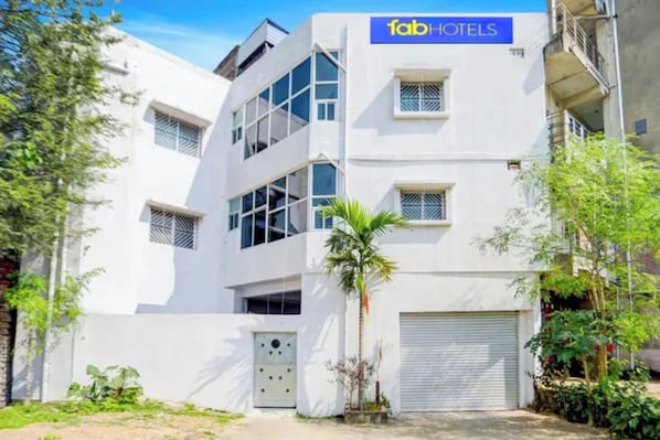 Um edifício moderno com uma placa indicando 'fabHOTELS' na fachada.
