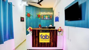 Una mesa de recepción con un cartel que dice 'fab hotels' y un cartel con el texto 'Hotel Ranch Retreat' encima.