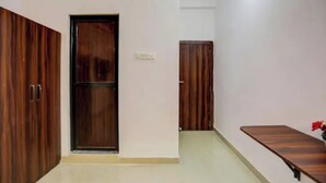 Una habitación con dos armarios de madera, una mesita y una puerta.