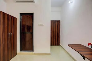 Una habitación con dos armarios de madera, una mesita y una puerta.