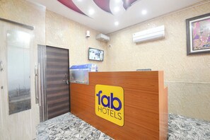 A reception desk with a 'fab hotels' sign, a security camera, and a framed picture on the wall. - Fabhotel Vrindavan Dham (Vrindavan)