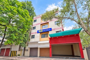 A multi-story building with a 'fabHOTELS' sign, a red awning, and a closed garage door. - Fabhotel Sai Seva (Nashik)