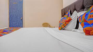 Une chambre d’hôtel avec un lit, une porte et une chaise.