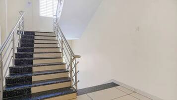A staircase with metal railings and a tiled floor leading to a landing.