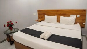 Un dormitorio con cama, mesita de noche, ventilador de techo y aire acondicionado.