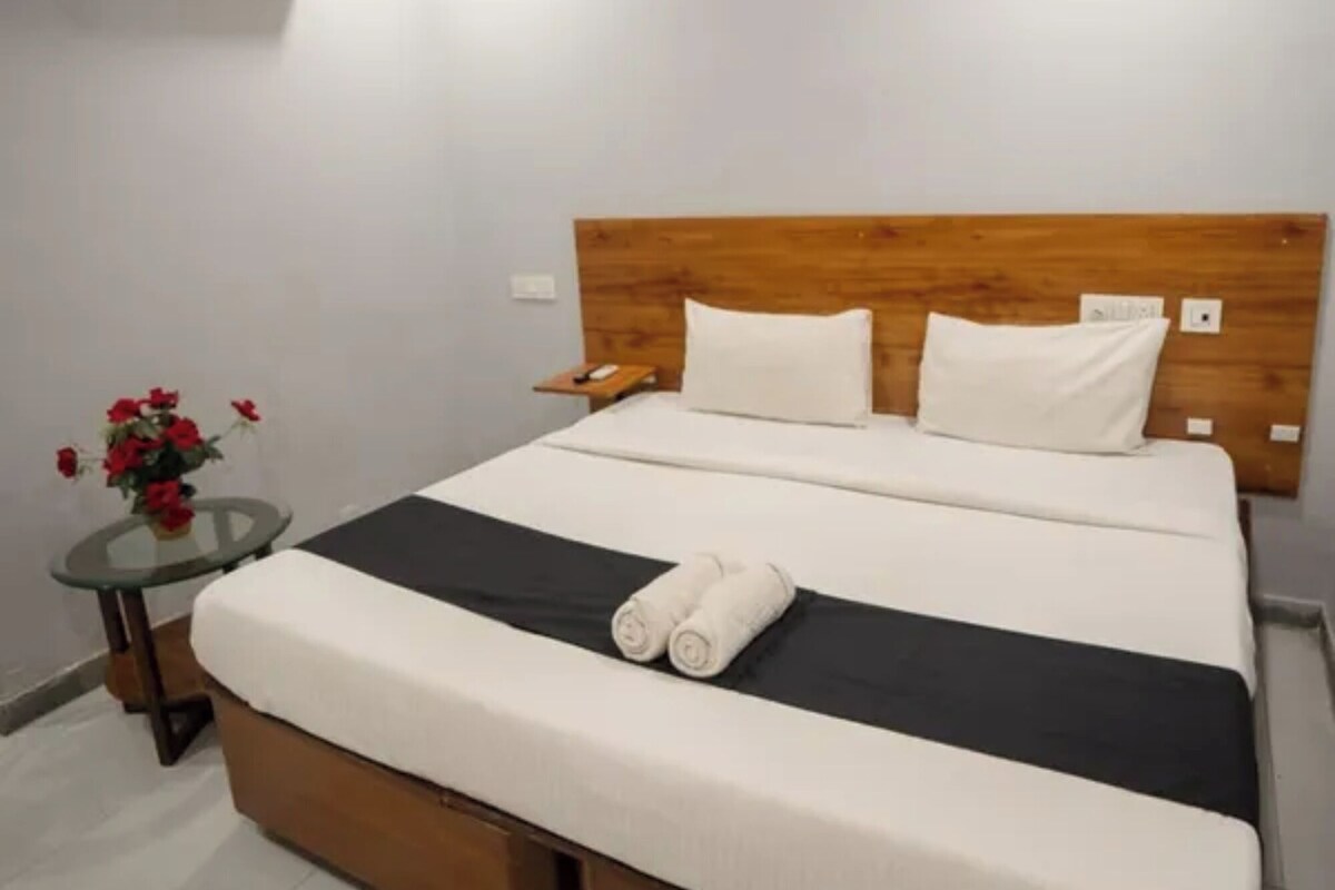 A bedroom with a bed, a nightstand, a ceiling fan, and an air conditioning unit.