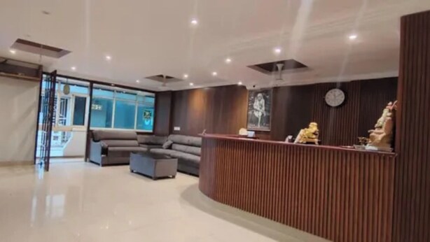 Un área de recepción con mostrador de madera, un sofá y una mesa de centro.