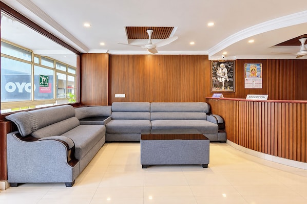 A reception area with a reception desk, a sofa, and a coffee table. - FabHotel Priya Residency (Hyderabad)
