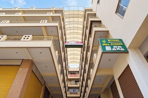 A multi-story building with a central atrium, balconies, and a sign for a hotel and mill stores. - FabHotel Priya Residency (Hyderabad)