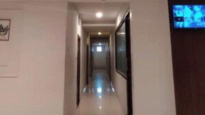 Un pasillo largo y estrecho con suelo de baldosas y techo plano.