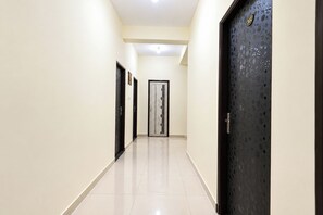 A hallway with doors on both sides, a tiled floor, and a ceiling light.