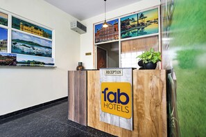 Una recepción con detalles de madera y un cartel que indica 'fab hotels'.