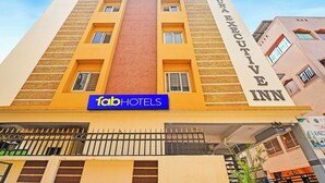 A multi-story building with a prominent 'fabHOTELS' sign and a 'Shree Executive Inn' sign on the side.