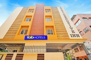 Un edificio de varios pisos con un letrero destacado de 'fabHOTELS' y un letrero lateral de 'Shree Executive Inn'.