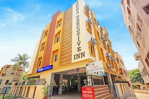 Un edificio de varios pisos con un letrero que dice 'Shree Aruna Executive Inn'.