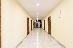 A hallway with wooden doors numbered 101 and 102, leading to an elevator. - FabHotel Aruna Executive Inn (Visakhapatnam)