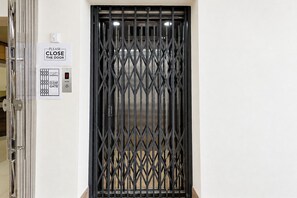A door with a security gate and a sign instructing to close the door. - Via Anasuya (Bhubaneshwar)