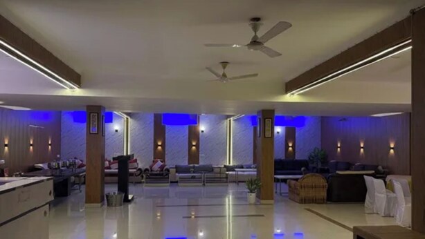 A spacious lobby with a modern design, featuring a central seating area, a reception desk, and a ceiling fan. - Fabhotel Aravali Residency (Gurugram)