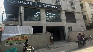 A multi-story building with a sign for a salon and tattoo shop on the ground floor. - Fabhotel Svr Inn (Hyderabad)