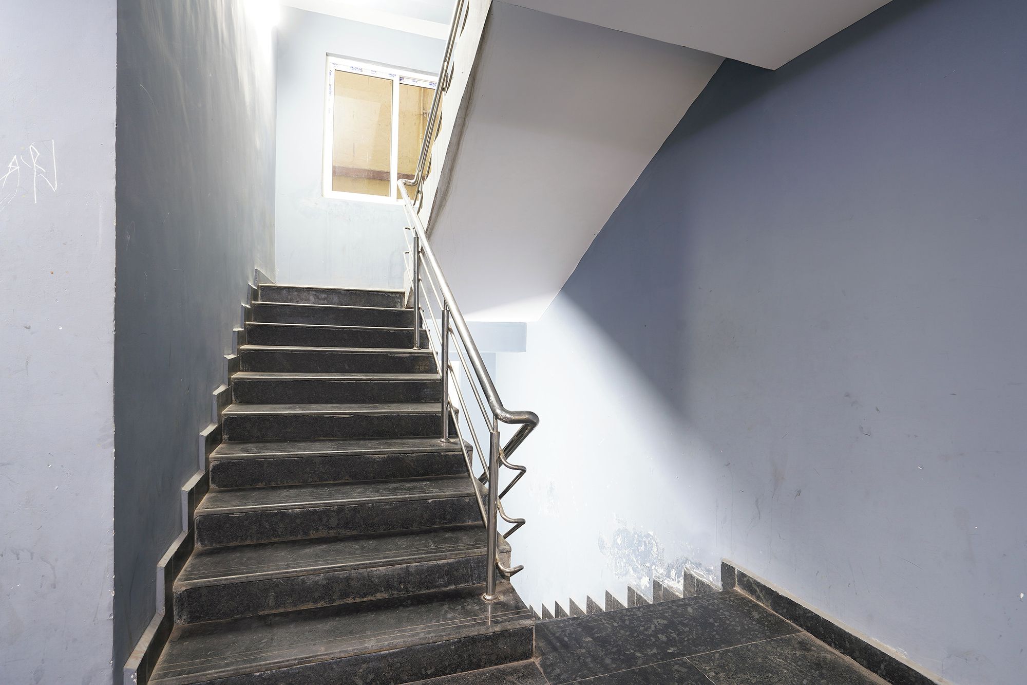 A staircase with metal railings leading to a landing.