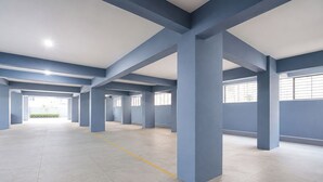 Amplio espacio interior con techos altos y columnas azules estructurales.