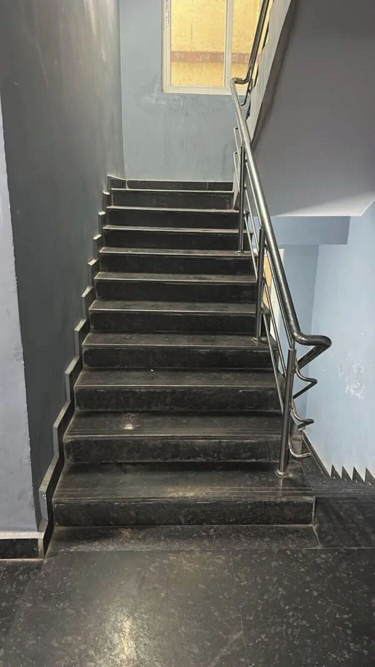 A staircase with metal railings and a window at the top.