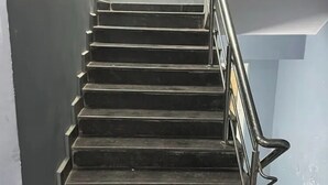 A staircase with metal railings and a window at the top.