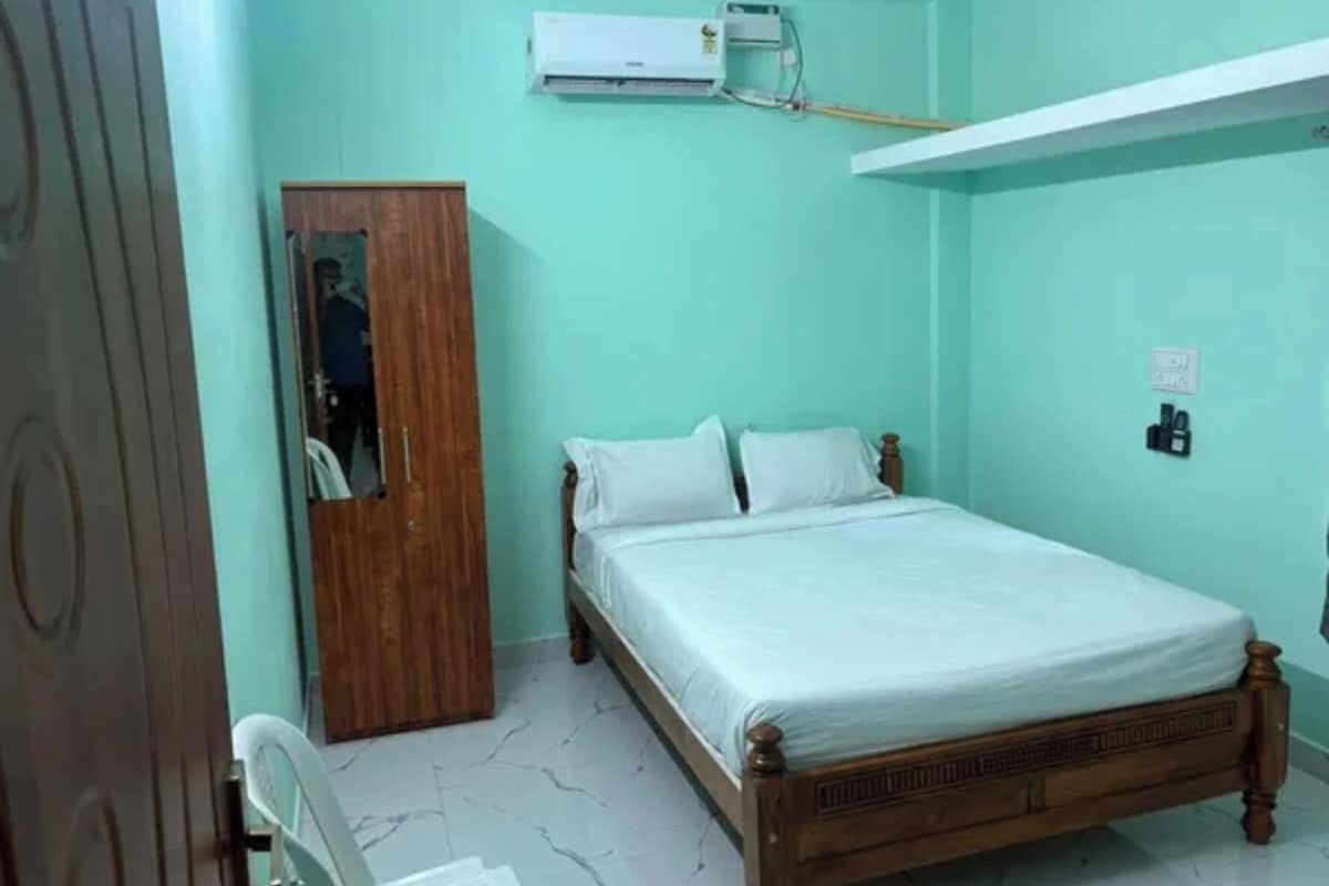 Un dormitorio con una cama, un armario y un equipo de aire acondicionado.