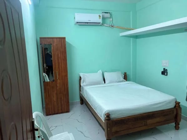 Un dormitorio con una cama, un armario y un equipo de aire acondicionado.