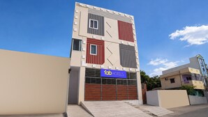 Un edificio moderno con un cartel que indica 'fab hotels', identificándolo como un establecimiento hotelero.
