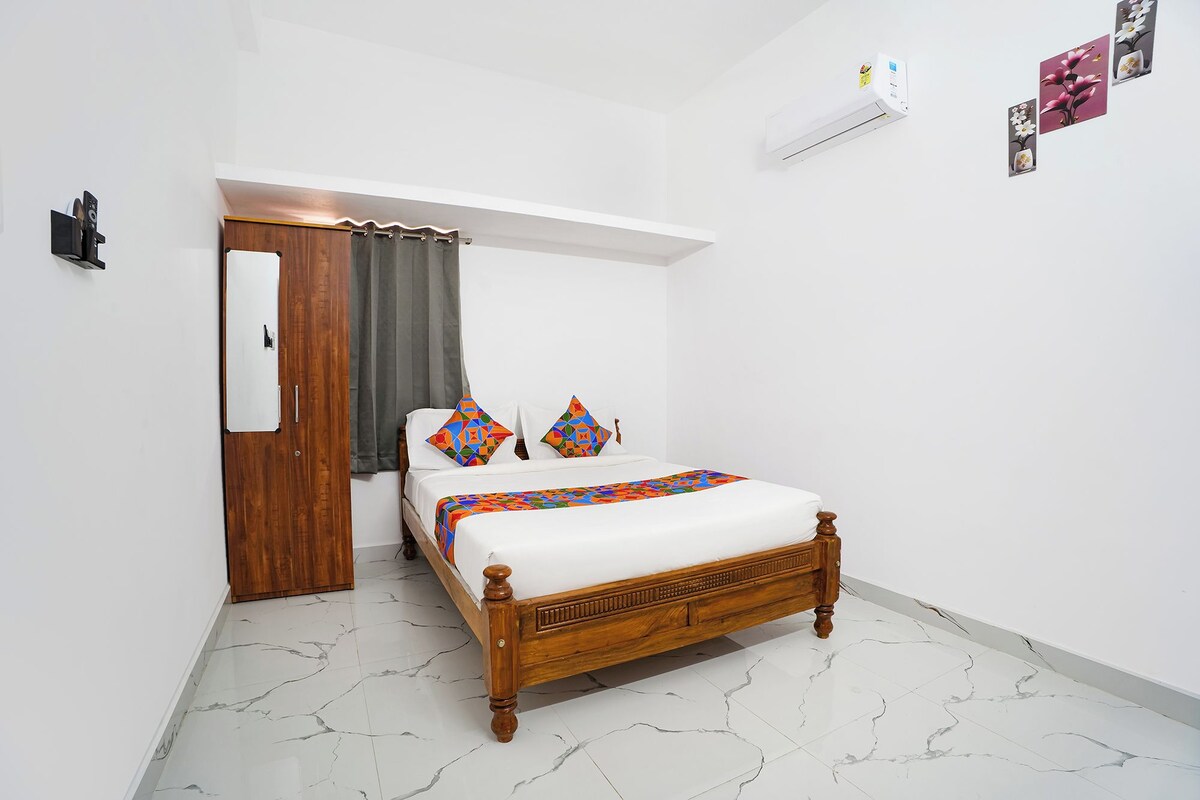 Un dormitorio con una cama de madera, una puerta, un equipo de aire acondicionado blanco y un aire acondicionado instalado en la pared.
