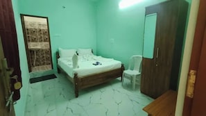 Una habitación con una cama, un armario y una silla.