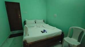 Una habitación con cama, una silla y una puerta.