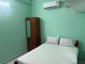 Una habitación con cama, armario y aire acondicionado.