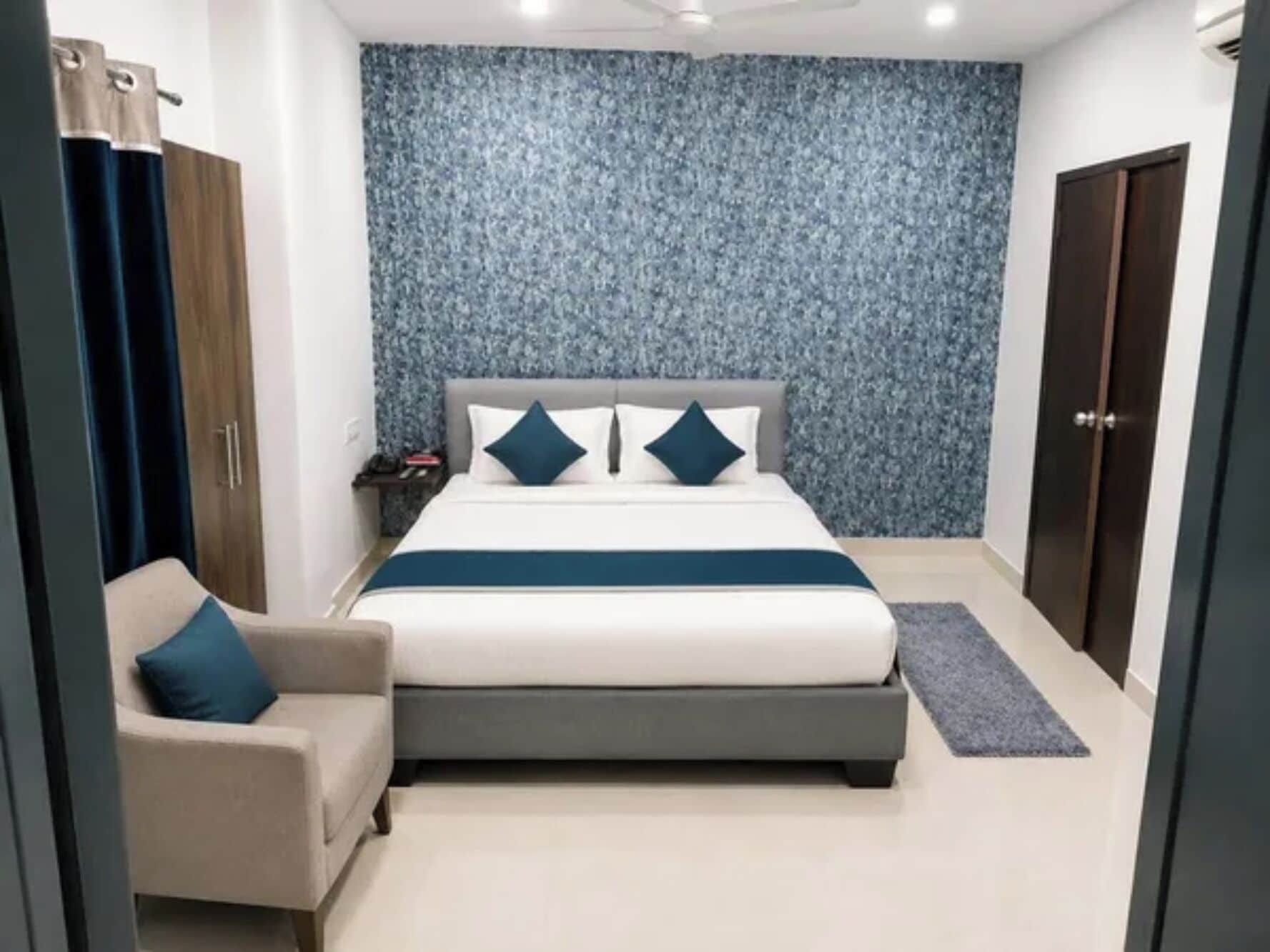 Een slaapkamer met een bed, nachtkastje, stoel en een garderobe.