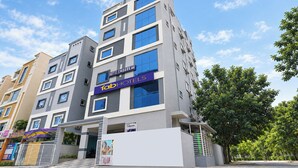 Un edificio de hotel moderno de varios pisos, con un letrero destacado de 'FabHotels' y un letrero de 'Hotel Embark Inn'.