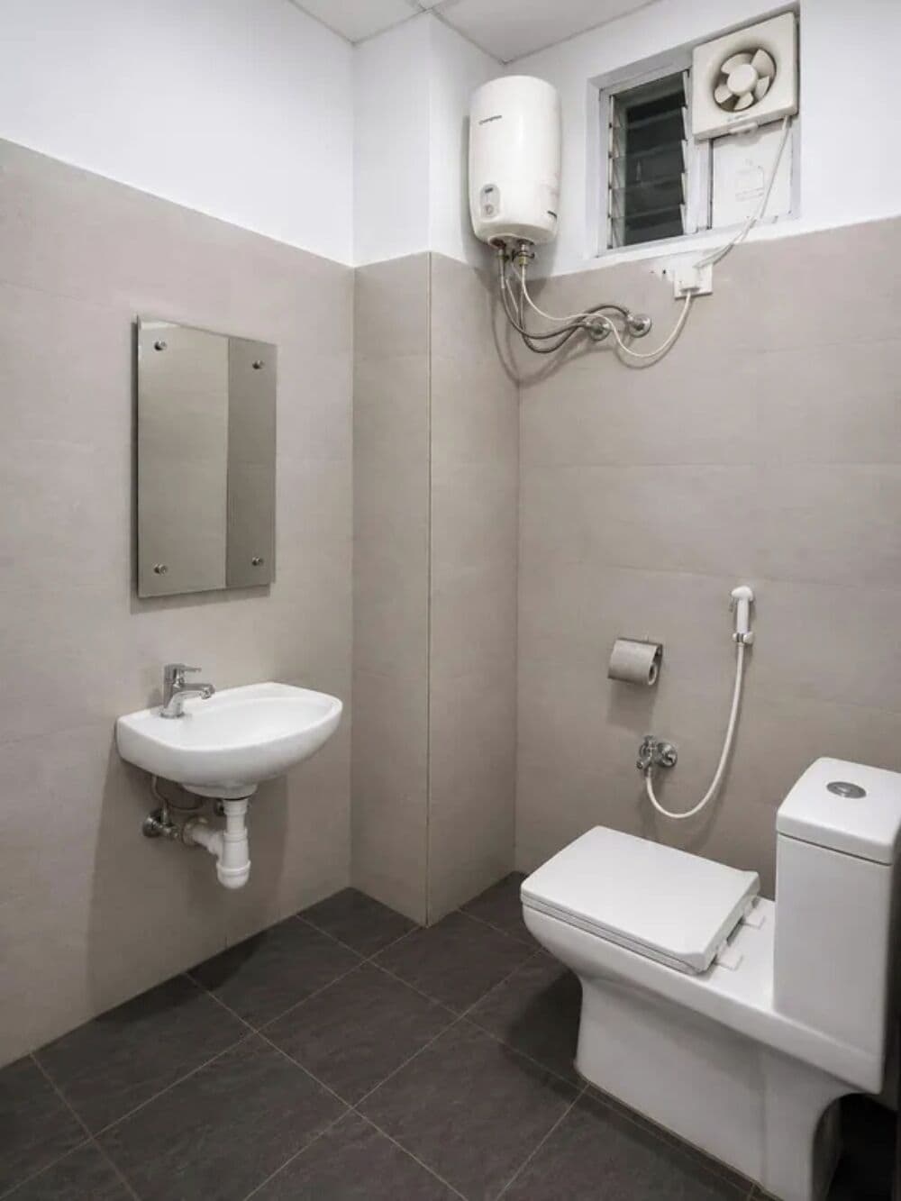 Een badkamer met een wastafel, toilet en een wandradiator.