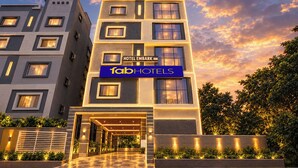 Un moderno edificio de hotel con un letrero llamativo que muestra 'Hotel Embark Inn' y la marca 'FabHotels'.