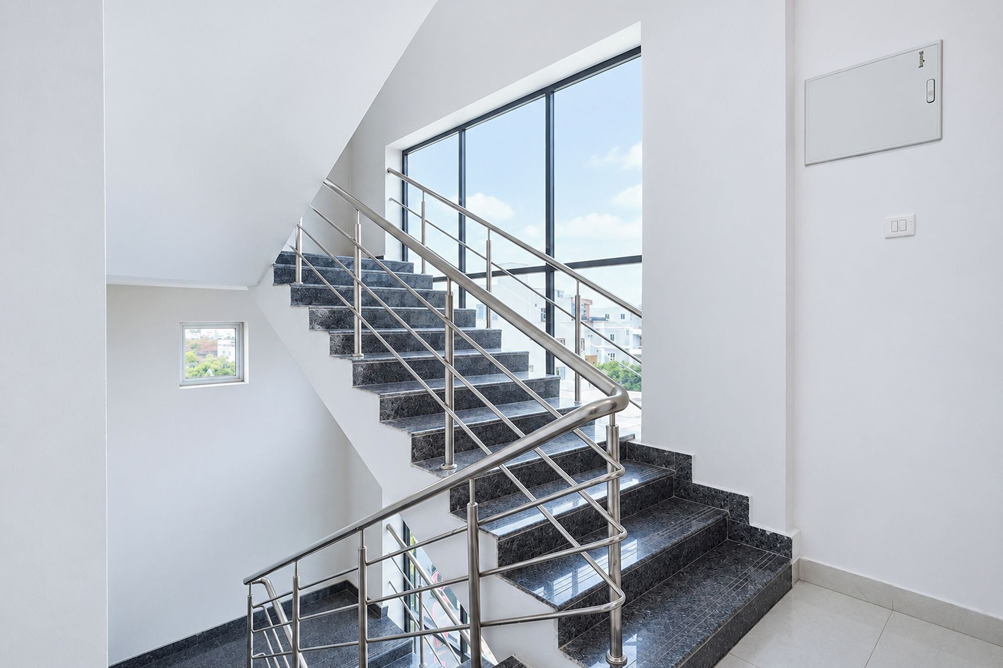 Eine moderne Treppe mit Metallgeländern, die zu einer zweiten Etage führt.