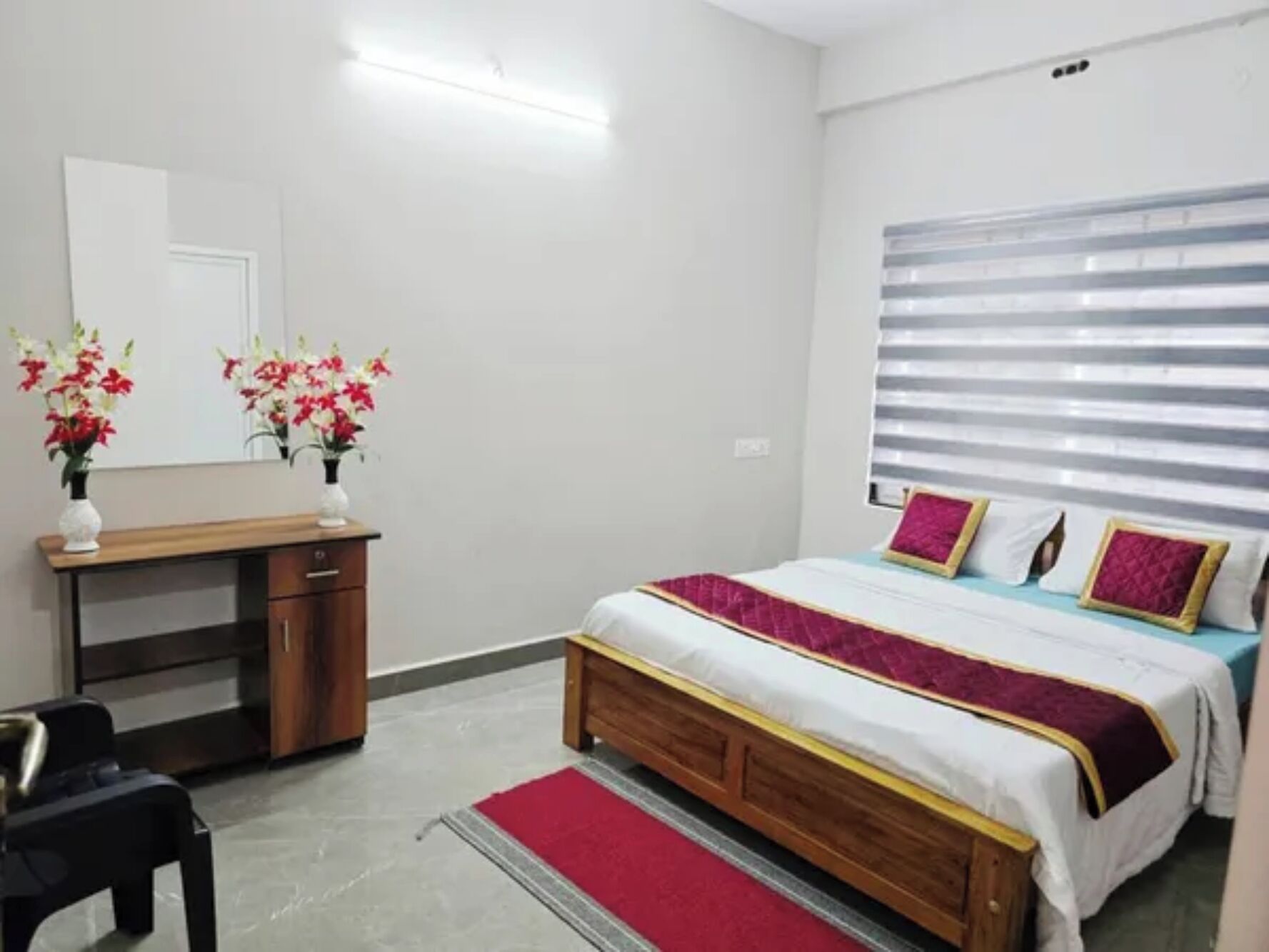 Un dormitorio con cama, mesita de noche y espejo.