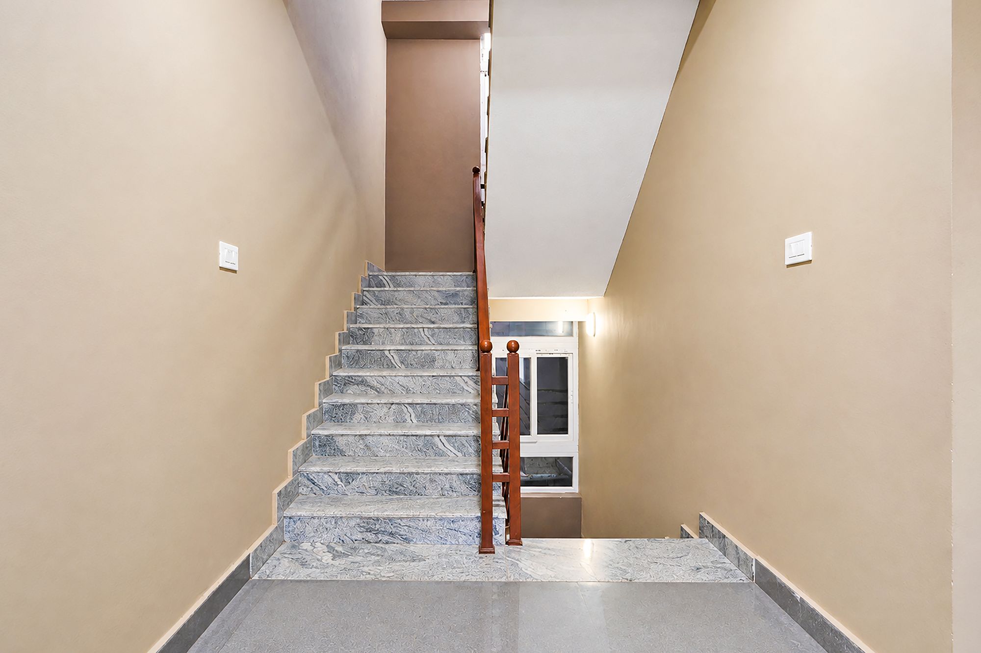 A staircase with a wooden handrail leading to a landing.