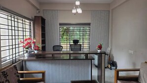 A modern dining area with a central island, seating arrangements, and a view through large windows.
