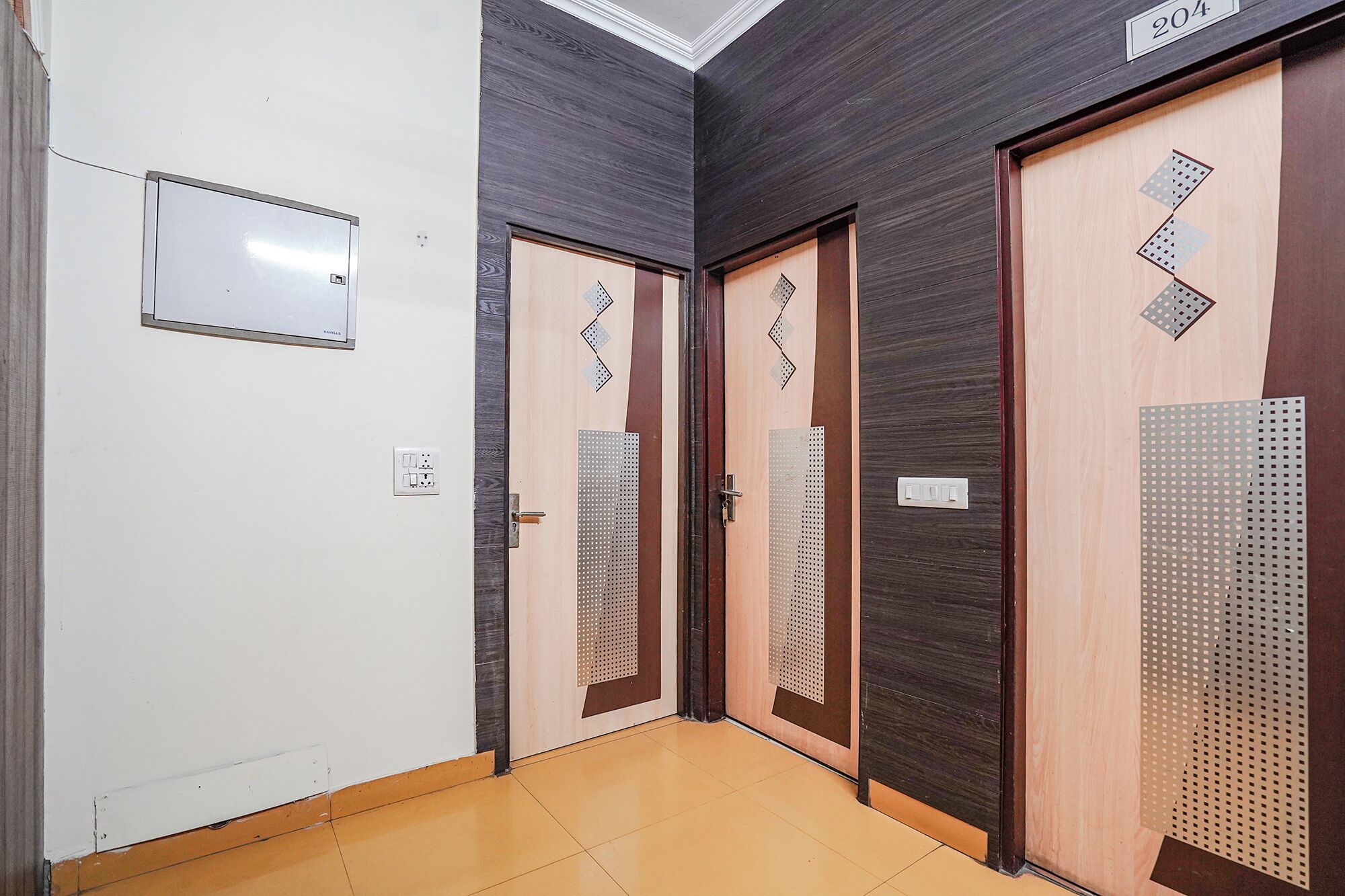 A hallway with three doors, each with a different design, and a whiteboard on the wall.