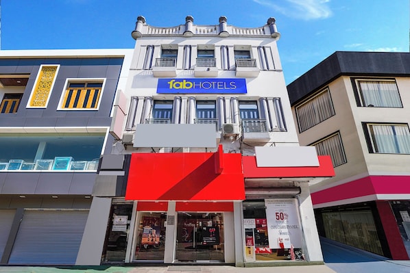 Un hotel con un llamativo letrero de 'fabHOTELS', varios balcones y una fachada con señalización visible.