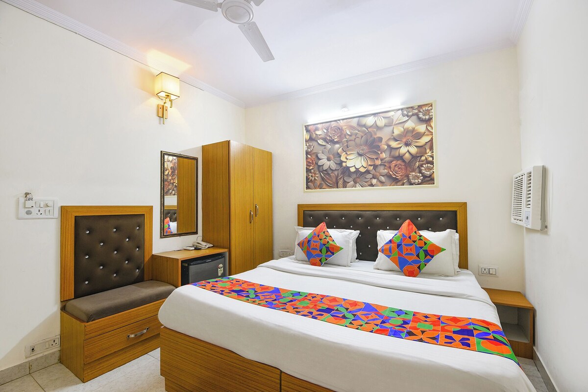 A bedroom with a bed, a nightstand, a dresser, a mirror, and a ceiling fan.