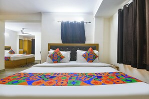 A hotel room with a large bed, a headboard, and a window with curtains. - Fabhotel Rivlet Central (New Delhi)